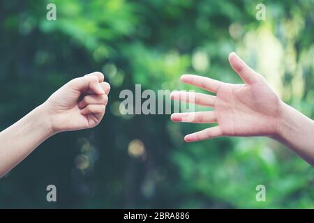 Paar spielen Rock Paper Scissors hand Spiel der Natur grüner Hintergrund Stockfoto