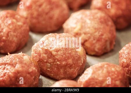 Rohe Klöße auf Fach frischem Hackfleisch in Form von Kugeln, mit Pfeffer, Salz. Close Up und Soft Focus Stockfoto