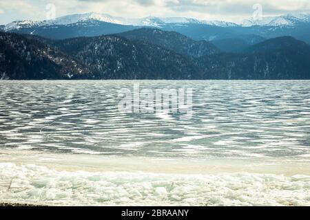 Blick auf den wunderschönen Zeichnungen auf Eis aus der Tiefe Risse und Blasen von Gas auf der Oberfläche des Sees Teletskoye, Russland Stockfoto