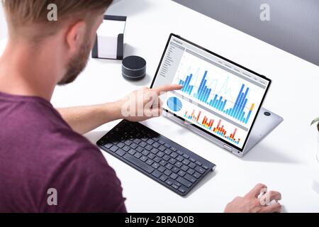 In der Nähe von einem Geschäftsmann Hand Analyse von Graphen auf Digital Laptop am Arbeitsplatz Stockfoto