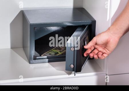 Eines Mannes Hand Bündel Banknoten in einem Safe Stockfoto