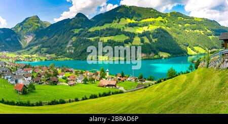 Schweizer Dorf Lungern mit seinen traditionellen Häusern und alten Kirchturm Alter Kirchturm entlang der wunderschönen smaragdgrünen See Firma Lungerersee, Kanton Obwalden Stockfoto