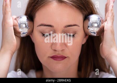 Nahaufnahme der jungen Frau die Meditation Mit chinesischen Stress Ball Stockfoto