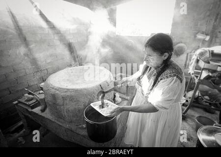 Ein einheimischer Koch serviert traditionelle Maulwurfsauce in einer rauchigen Hütte in San Vicente Coatlan, Oaxaca, Mexiko. Stockfoto