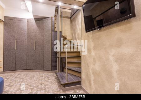 Großer Schrank im Flur, Treppe zum zweiten Stock, TV an der Wand Stockfoto