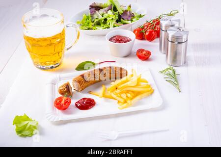 Leckere Bratwurst mit Brötchen und Bier Stockfoto