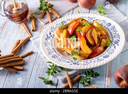 Köstliche Dessert mit frischen Pfirsichen, gebraten mit Ahornsirup und French Toast Stockfoto