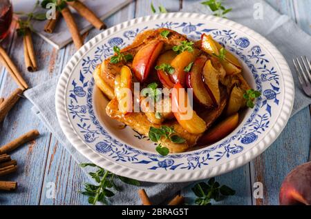 Köstliche Dessert mit frischen Pfirsichen, gebraten mit Ahornsirup und French Toast Stockfoto