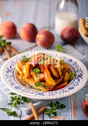 Köstliche Dessert mit frischen Pfirsichen, gebraten mit Ahornsirup und French Toast Stockfoto