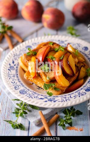 Köstliche Dessert mit frischen Pfirsichen, gebraten mit Ahornsirup und French Toast Stockfoto