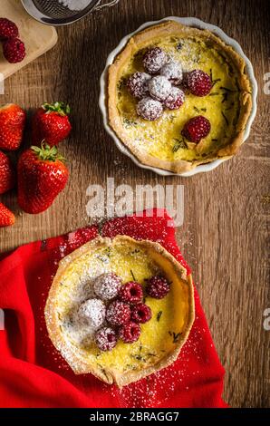 Zitronentorte mit Rosmarin und Beeren, gefüllt mit Sahne garniert Beeren Stockfoto