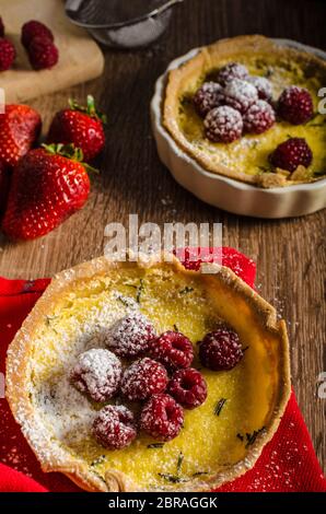 Zitronentorte mit Rosmarin und Beeren, gefüllt mit Sahne garniert Beeren Stockfoto