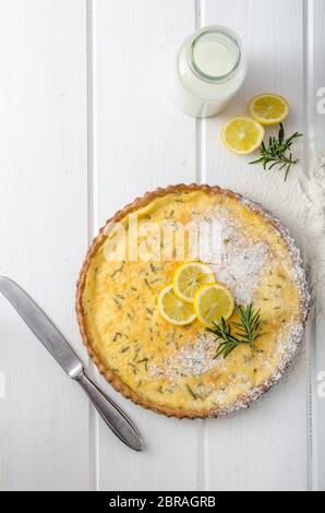 Zitronenkuchen mit Rosmarin, süßem Quiche, Milch und frischen Kräutern aus dem Garten Stockfoto