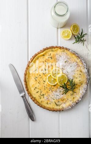 Zitronenkuchen mit Rosmarin, süßem Quiche, Milch und frischen Kräutern aus dem Garten Stockfoto