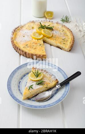 Zitronenkuchen mit Rosmarin, süßem Quiche, Milch und frischen Kräutern aus dem Garten Stockfoto