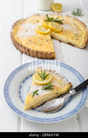 Zitronenkuchen mit Rosmarin, süßem Quiche, Milch und frischen Kräutern aus dem Garten Stockfoto