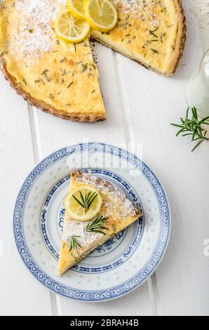 Zitronenkuchen mit Rosmarin, süßem Quiche, Milch und frischen Kräutern aus dem Garten Stockfoto