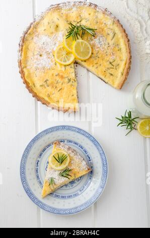 Zitronenkuchen mit Rosmarin, süßem Quiche, Milch und frischen Kräutern aus dem Garten Stockfoto