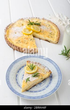 Zitronenkuchen mit Rosmarin, süßem Quiche, Milch und frischen Kräutern aus dem Garten Stockfoto