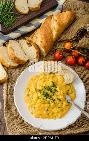 Französische Rührei mit Schnittlauch mit französischen Baguette und Mini-Tomaten Stockfoto