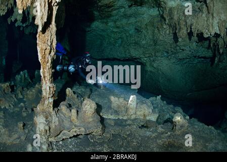 Sidemount technischer Taucher mit Taschenlampe in Cenote Car Wash bei Tulum Stockfoto