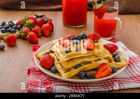 Belgische Waffeln mit Heidelbeeren, Erdbeeren mit Schokolade überzogen Stockfoto
