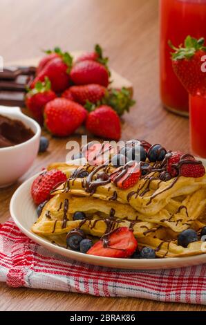 Belgische Waffeln mit Heidelbeeren, Erdbeeren mit Schokolade überzogen Stockfoto