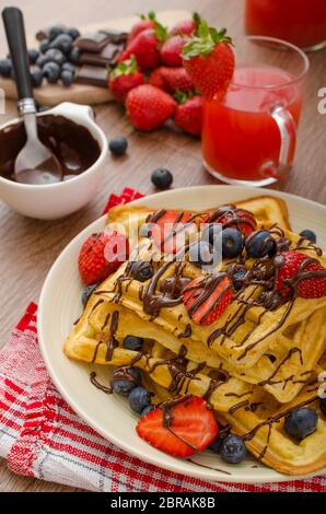 Belgische Waffeln mit Heidelbeeren, Erdbeeren mit Schokolade überzogen Stockfoto