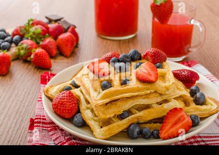Belgische Waffeln mit Heidelbeeren, Erdbeeren mit Schokolade überzogen Stockfoto