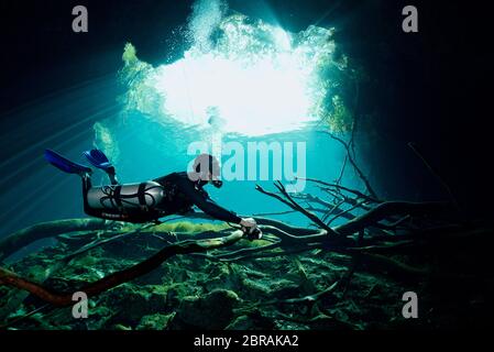 Sidemount technischer Taucher mit Taschenlampe in Cenote Car Wash bei Tulum Stockfoto