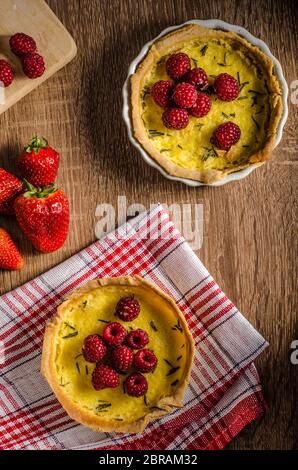 Zitronentorte mit Rosmarin und Beeren, gefüllt mit Sahne garniert Beeren Stockfoto