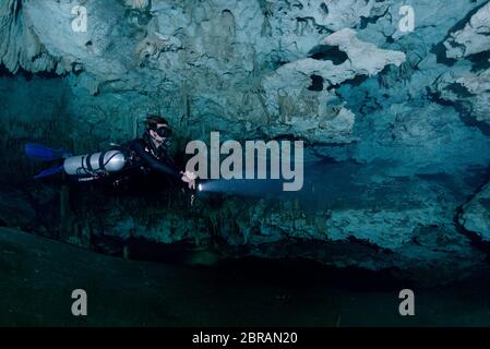 Sidemount Technical Diver schwimmt um einzigartige Kalksteinformationen im Cenote Dreamgate in Mexiko. Stockfoto