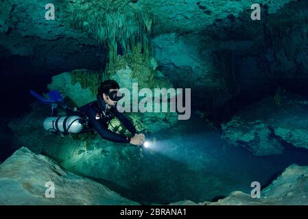 Sidemount Technical Diver schwimmt um einzigartige Kalksteinformationen im Cenote Dreamgate in Mexiko. Stockfoto