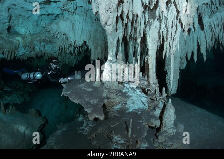 Sidemount Technical Diver schwimmt um einzigartige Kalksteinformationen im Cenote Dreamgate in Mexiko. Stockfoto