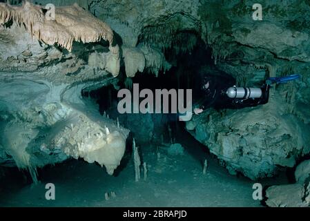 Sidemount Technical Diver schwimmt um einzigartige Kalksteinformationen im Cenote Dreamgate in Mexiko. Stockfoto