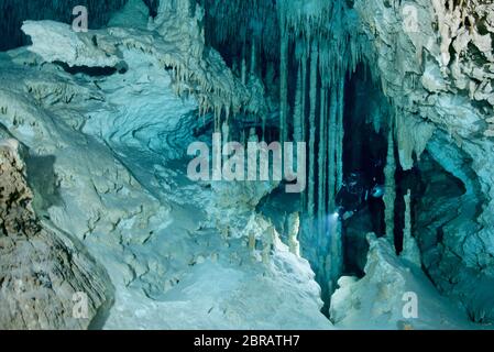 Sidemount Technical Diver schwimmt um einzigartige Kalksteinformationen im Cenote Dreamgate in Mexiko. Stockfoto