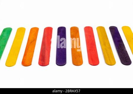 Reihe der farbigen Holzlatten auf eine weiße Fläche Stockfoto