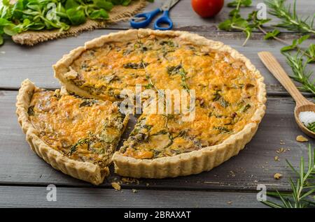 Inländische rustikale Quiche, gefüllte Zwiebel Kräuter, Knoblauch und Salat. Stockfoto