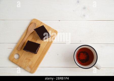 Brownie Kuchen auf einem Bambus tablett mit cuo von Tee auf einem weißen Holz- Hintergrund mit Platz für textt. top View Stockfoto