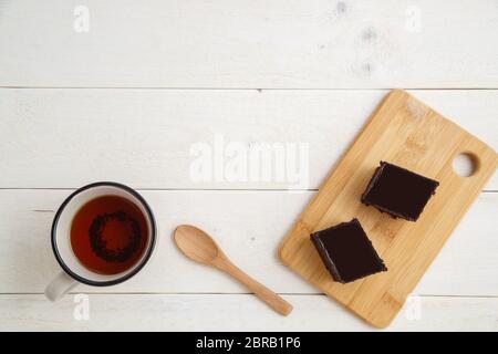 Brownie Kuchen auf einem Bambus tablett mit cuo von Tee auf einem weißen Holz- Hintergrund mit Platz für textt. top View Stockfoto