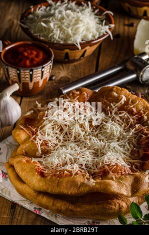 Traditionelle Langos sind ursprünglich ungarische Pfannkuchen aus Hefeteig, gekrönt mit Käse, Knoblauch und Tomatenketchup. Dieses Gericht wird verkauft bei Stockfoto