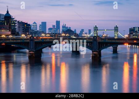 Allgemeine Ansicht der Themse im Zentrum Londons bei Sonnenaufgang, mit Southwark Bridge, Tower Bridge und Wolkenkratzern am Canary Wharf, nach der Einführung von Maßnahmen, um das Land aus der Blockierung zu bringen. Stockfoto