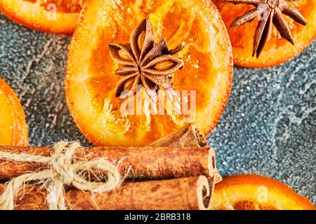 Scheiben getrockneter Orangen oder Mandarinen mit Anis und Zimt, auf blauem Hintergrund. Vegetarismus und gesunde Ernährung. Stockfoto