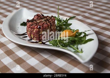 Der Tartar ist ein Gericht der französischen Ursprungs aus Rind oder Pferd Fleisch roh serviert wird und mit einem Messer in sehr kleine Stücke geschnitten. Mit grünen serviert. Stockfoto