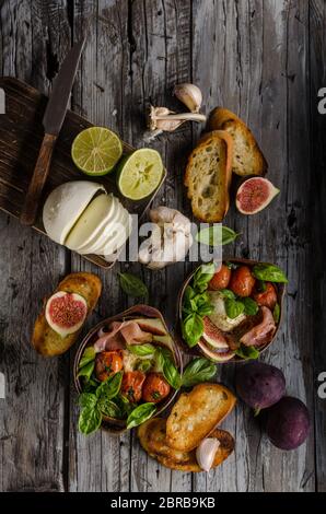 Herby Salat, frische Feigen, gebackene Tomaten, Basilikum und frisch gerösteten Knoblauch Toast Stockfoto