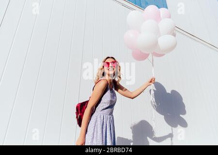 Schön lustig curly Frau in rosa Sonnenbrille genießen Sie den sonnigen Tag, Luftballons, top und freundlich lächelnd, tragen Sommer Kleid, wi Stockfoto