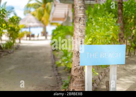 Holzschild am tropischen Strandweg zum Restaurant und der Strandbar Stockfoto