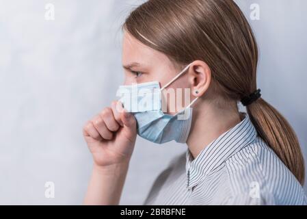 Teenager-Mädchen in medizinischen Maske, Husten und Halsschmerzen, Krankheit und Temperatur, Seitenansicht Nahaufnahme, Vorsicht Viruserkrankung und Grippe und Krankheit, zu Hause bleiben Stockfoto