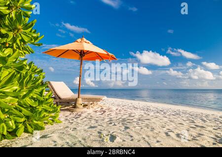 Tropische Landschaft mit Liegen oder Stühlen mit Sonnenschirm am Sandstrand in der Nähe des Meeres. Luxus Sommerurlaub, exotische Reise Abenteuer. Tropische Natur Stockfoto