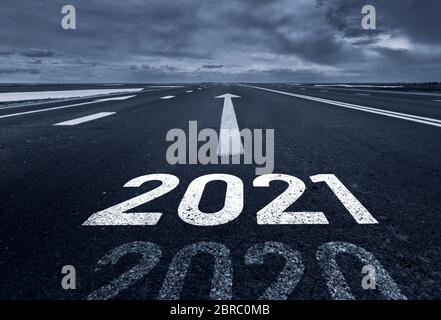 Eine Wüstenstraße mit der Inschrift 2021 2020. Konzept des abgehenden alten Jahres und neue Ziele. Stockfoto